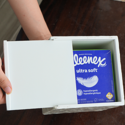 A hand slides open a white capiz shells tissue cover box, revealing a 60-count tissue box of Kleenex Ultra Soft tissues inside.